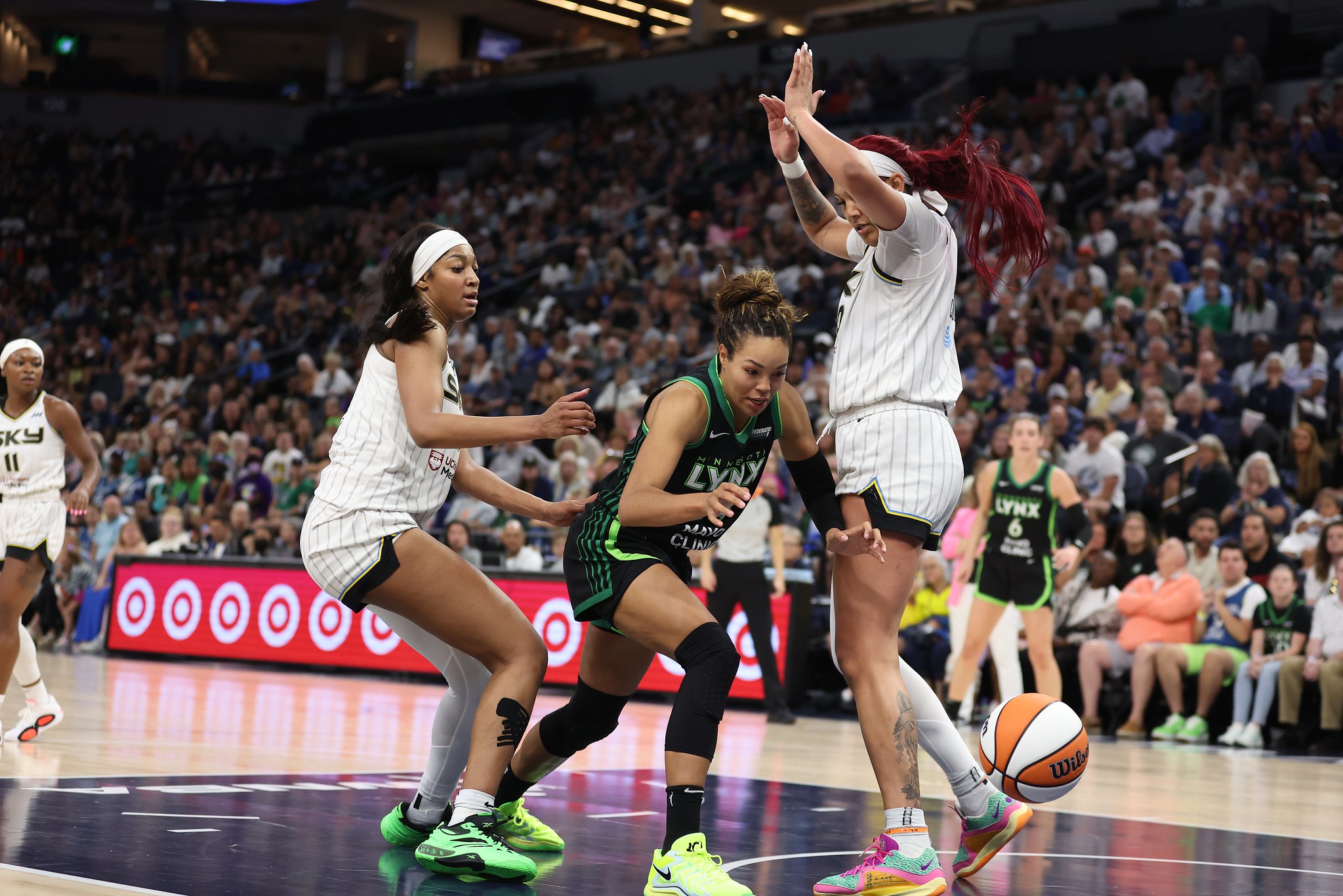 Minnesota Lynx forward Napheesa Collier goes for a loose ball against Chicago Sky center Kamilla Cardoso and forward Angel Reese