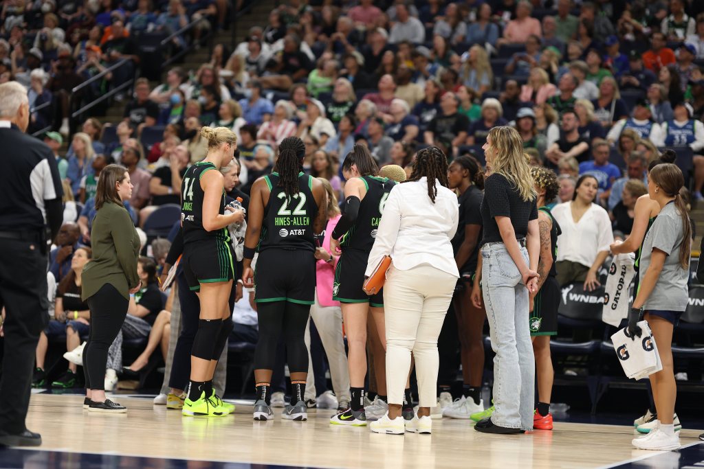 The Minnesota Lynx huddle around head coach Cheryl Reeve during a game.