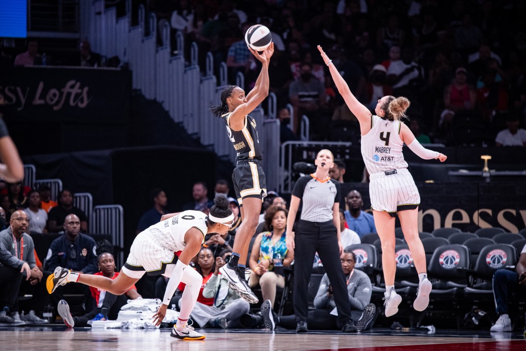Washington Mystics guard Shatori Walker-Kimbrough is shown in profile attempting a right-handed jump shot. A Chicago Sky defender jumps to contest it but isn't close enough to affect the shot.