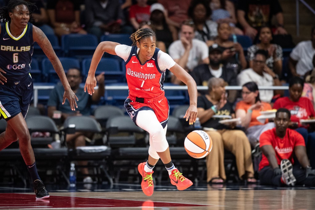 Washington Mystics guard Ariel Atkins runs down the court, pushing the ball out in front of her with her left hand.