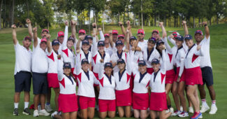 U.S.A. players and caddies pose in a group and raise their arms in victory after winning the Solheim Cup