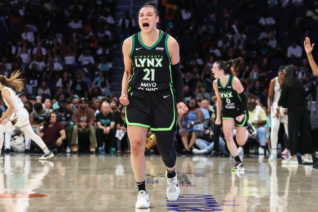 Minnesota Lynx guard Kayla McBride yells and clenches both fists in celebration. In the background, forward Bridget Carleton makes a similar gesture.