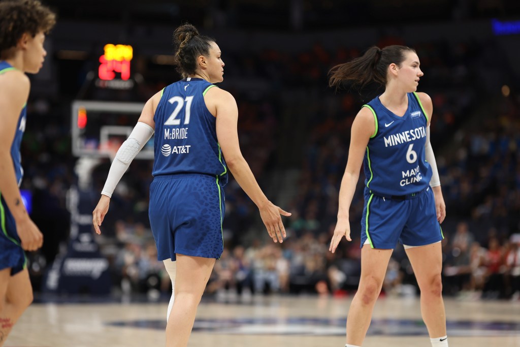 Minnesota Lynx guard Kayla McBride turns toward forward Bridget Carleton with her right palm facing Carleton for a high five.