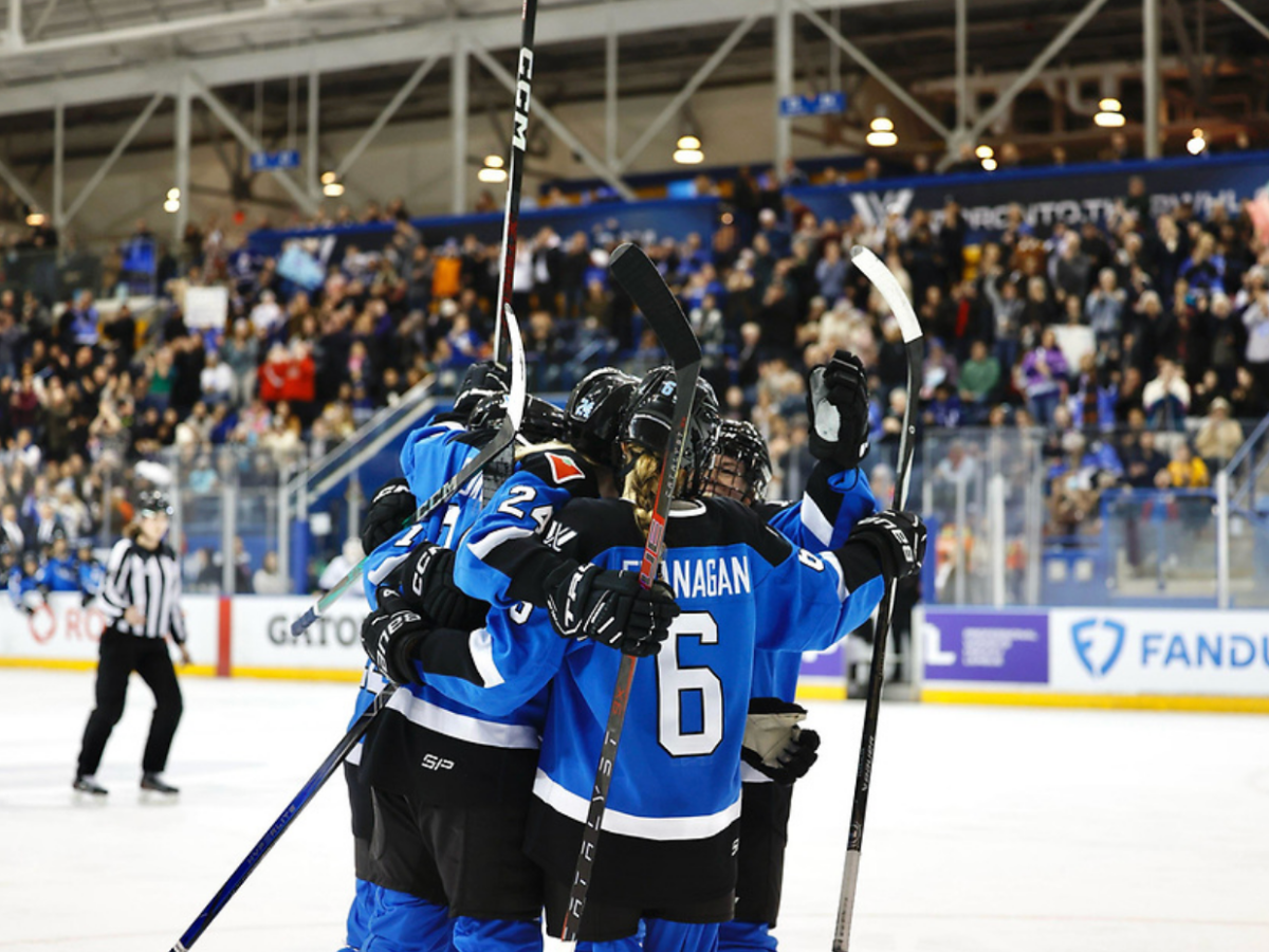 Five Toronto players celebrate a goal with a tight group hug. They are all wearing blue home uniforms.