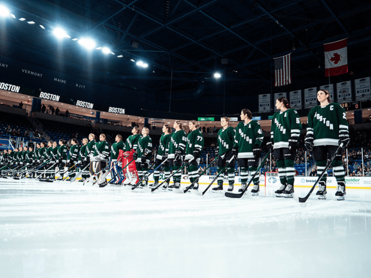 The whole Boston roster stands along the blue line, looking straight ahead while wearing green home jerseys.