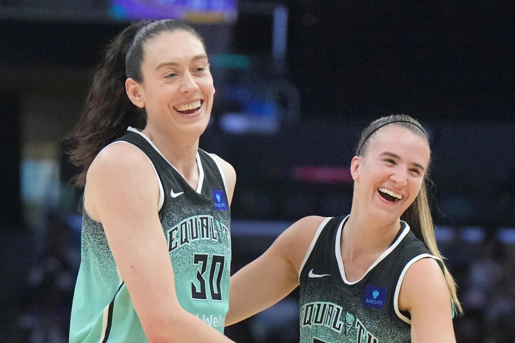A close-up photo of Breanna Stewart and Sabrina Ionescu smiling together during a game.