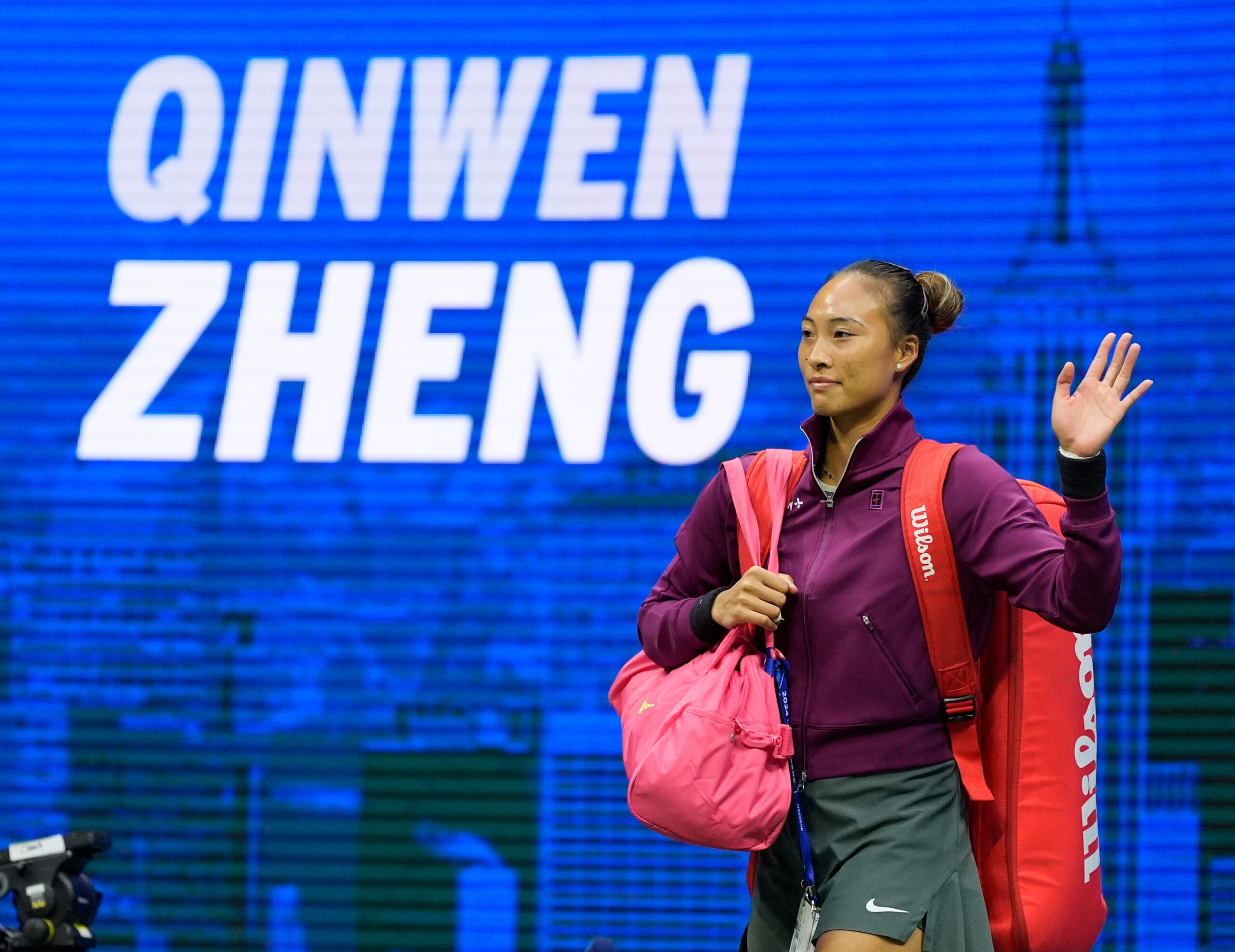 Zheng Qinwen waves to the crowd as she entered the court at the 2024 U.S. Open.