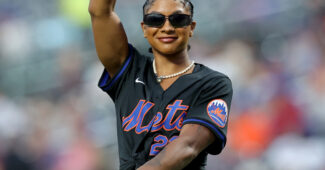 Jordan Chiles, in a black Mets minidress, prepares to throw a pitch.