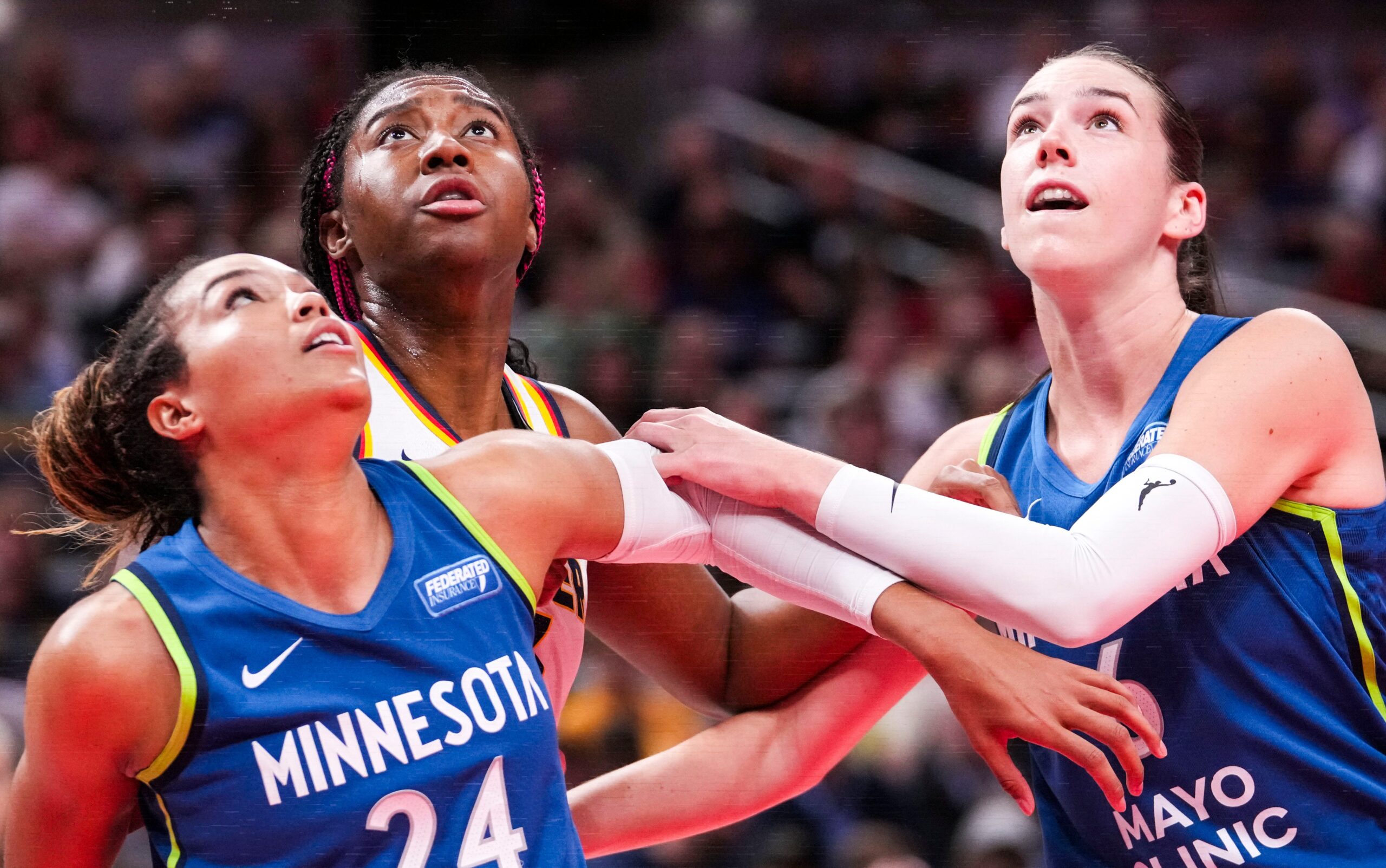 Napheesa Collier and Bridget Carleton of the Minnesota Lynx box out Indiana Fever's Aliyah Boston