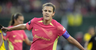 Christine Sinclair celebrates a goal with outstretched arms