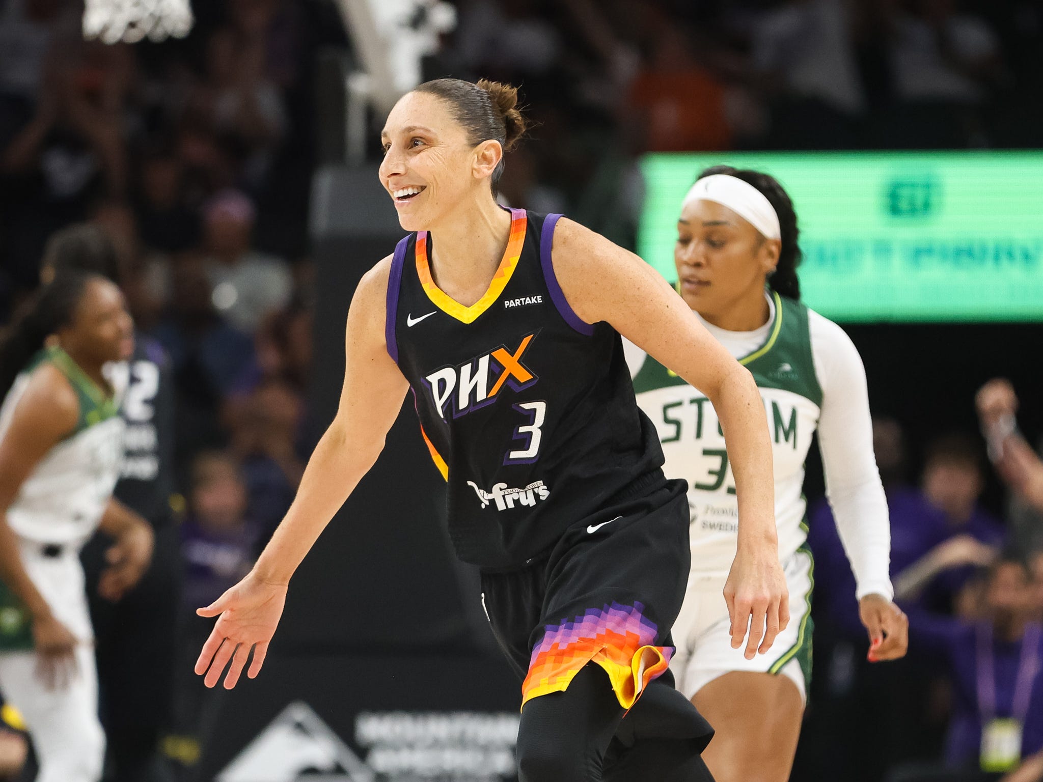 Diana Taurasi smiles while running on the basketball court