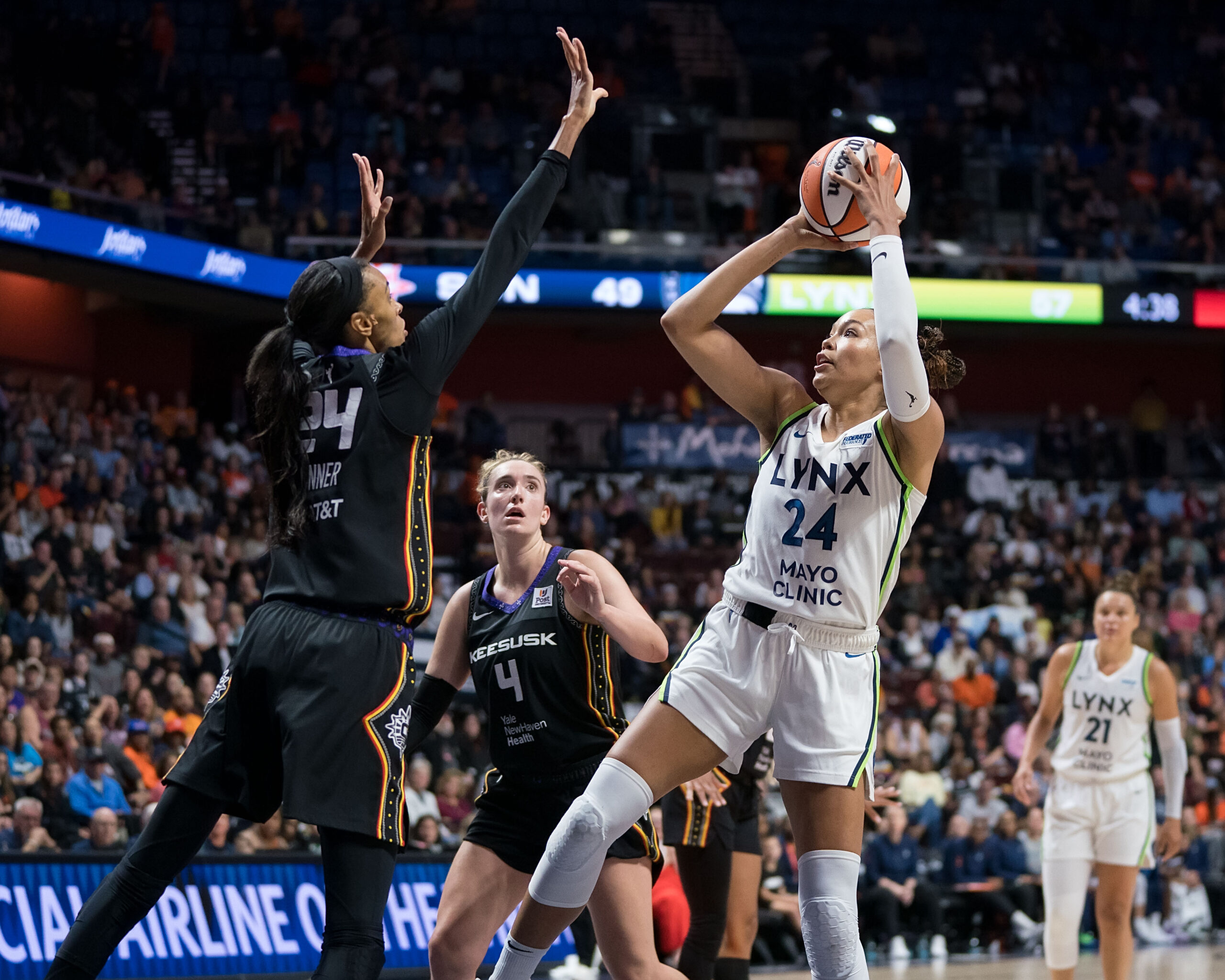 Napheesa Collier (right) shoots a basketball over DeWanna Bonner (left)