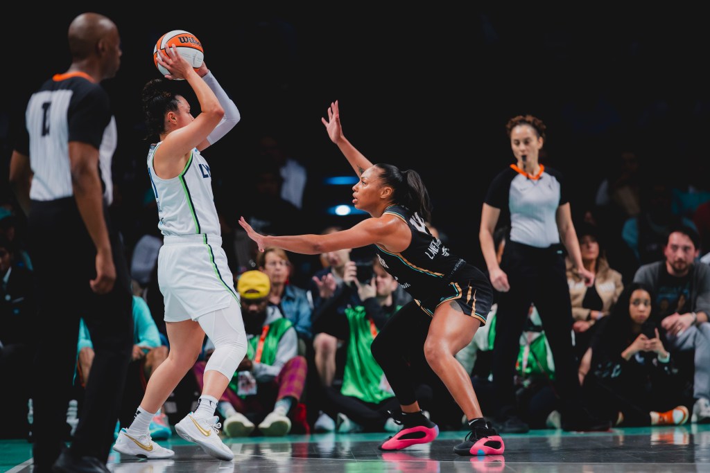 Betnijah Laney-Hamilton is in a crouched defensive stance with raised arms while defending Kayla McBride