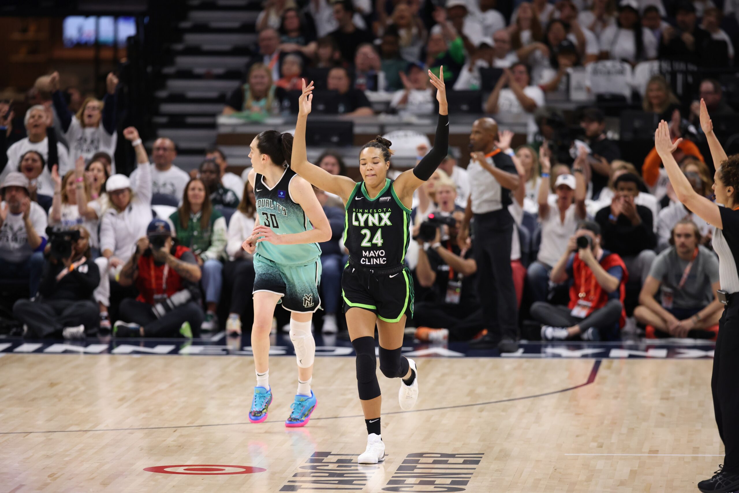 Napheesa Collier (24) runs down the court with her arms raised
