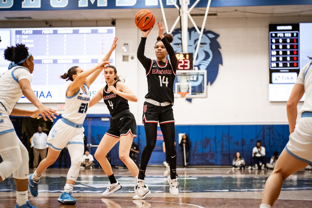 Harvard guard Harmoni Turner shoots a right-handed jump shot near the free-throw line. A Columbia defender approaches from the side but is too late to contest the shot.
Ivy League