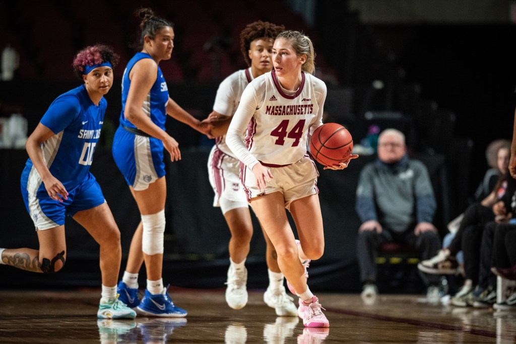 Stefanie Kulesza looks to her right with the basketball in her lefthand ahead of two Saint Louis defenders.