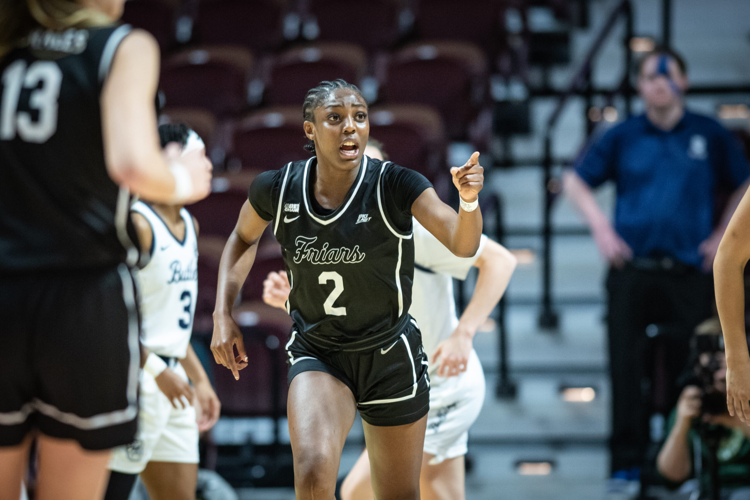 Grace Efosa runs up the court with left hand raised to point to a teammate