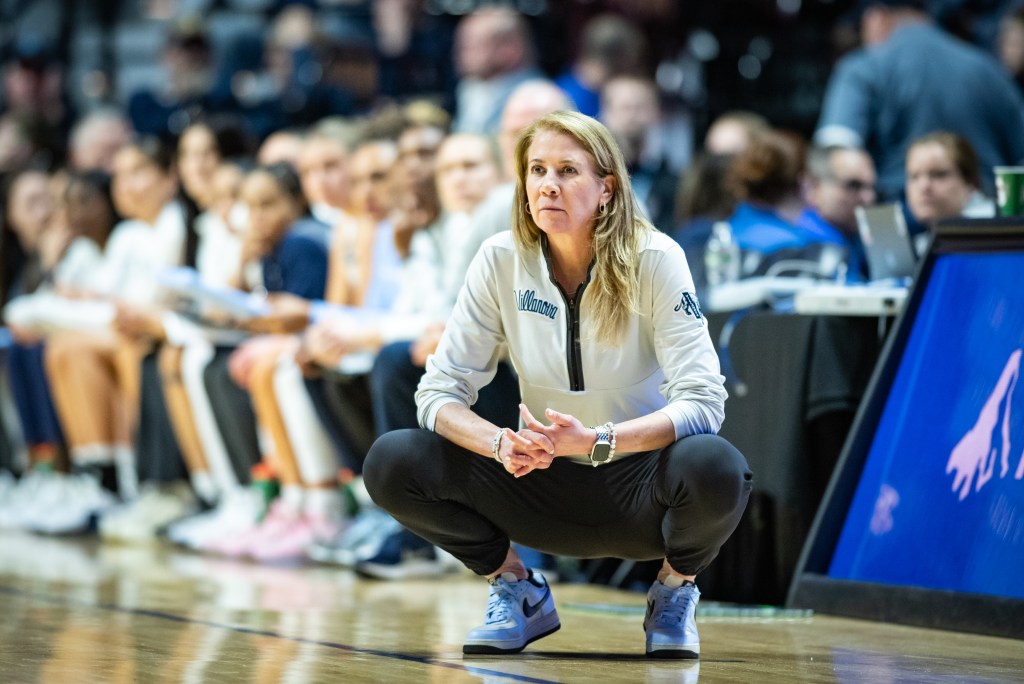 Villanova head coach Denise Dillon crouches on the sideline while looking on to the game action
BIG EAST