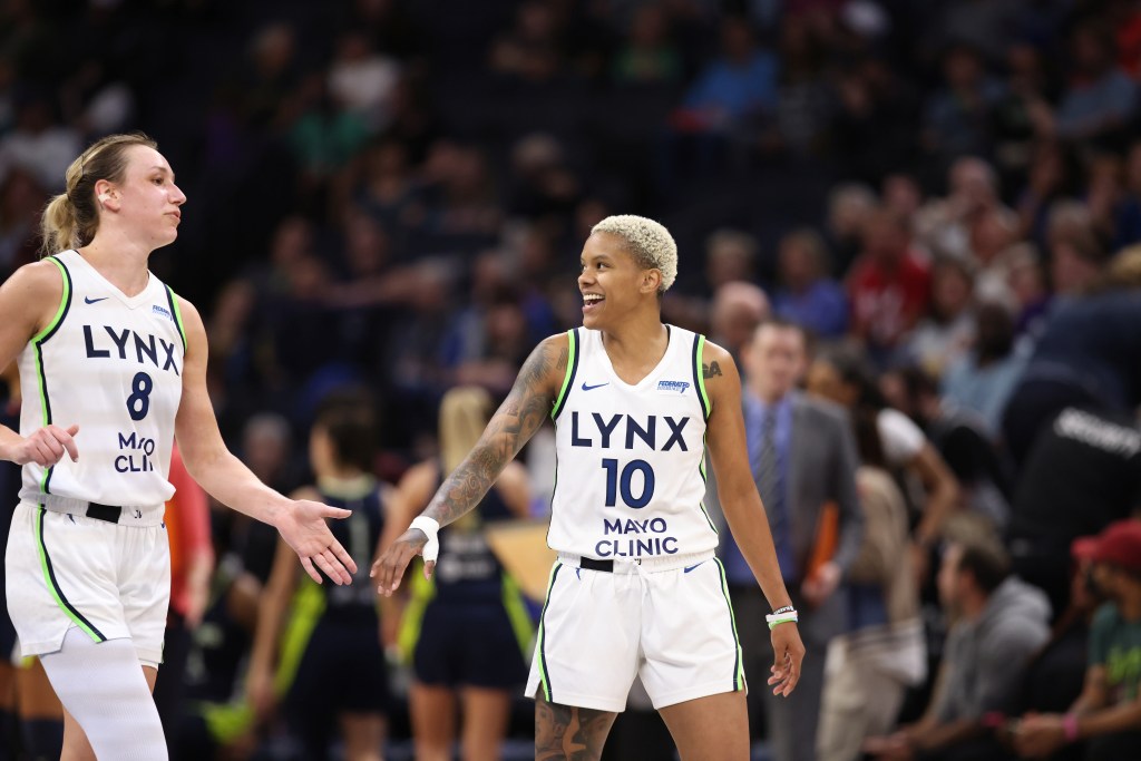 Minnesota Lynx teammates Alanna Smith and Courtney Williams high-five. Williams smiles as she looks at Smith.