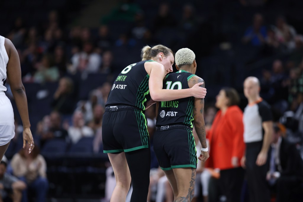 Alanna Smith puts her arms around Courtney Williams. Both players are shown from behind.