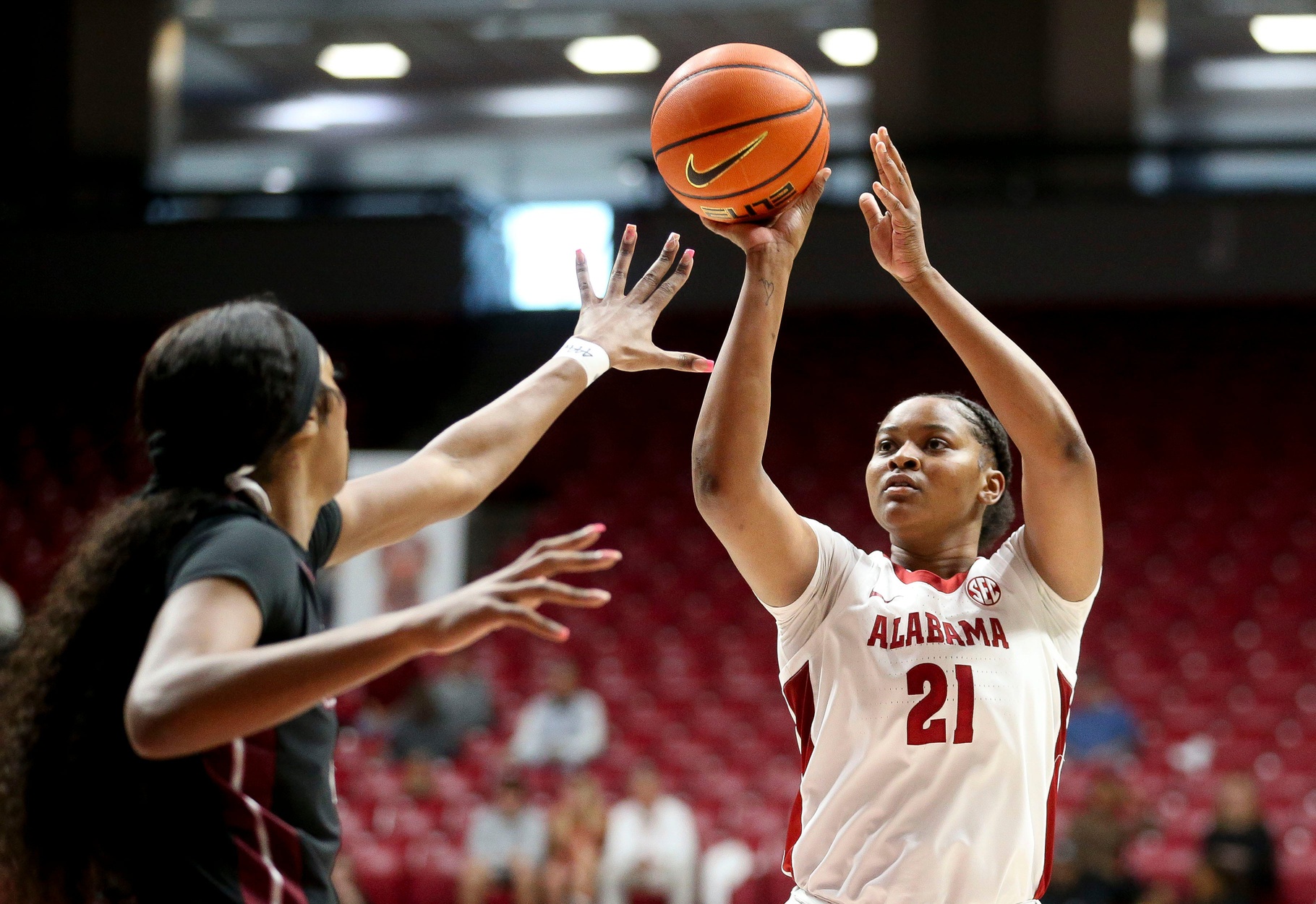 Alabama women's basketball forward Essence Cody (21) takes a shot over a defender during a game against Mississippi State