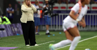 Emma Hayes watched in the background as play unfolds on the soccer field