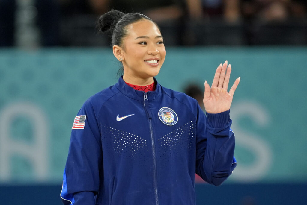 Suni Lee waves to the audience during the Olympics