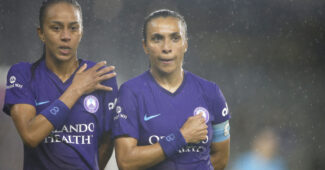 Orlando Pride forwards Adriana Leal da Silva (9) and Marta (10) stand with hands on chests in the rain prior to a match