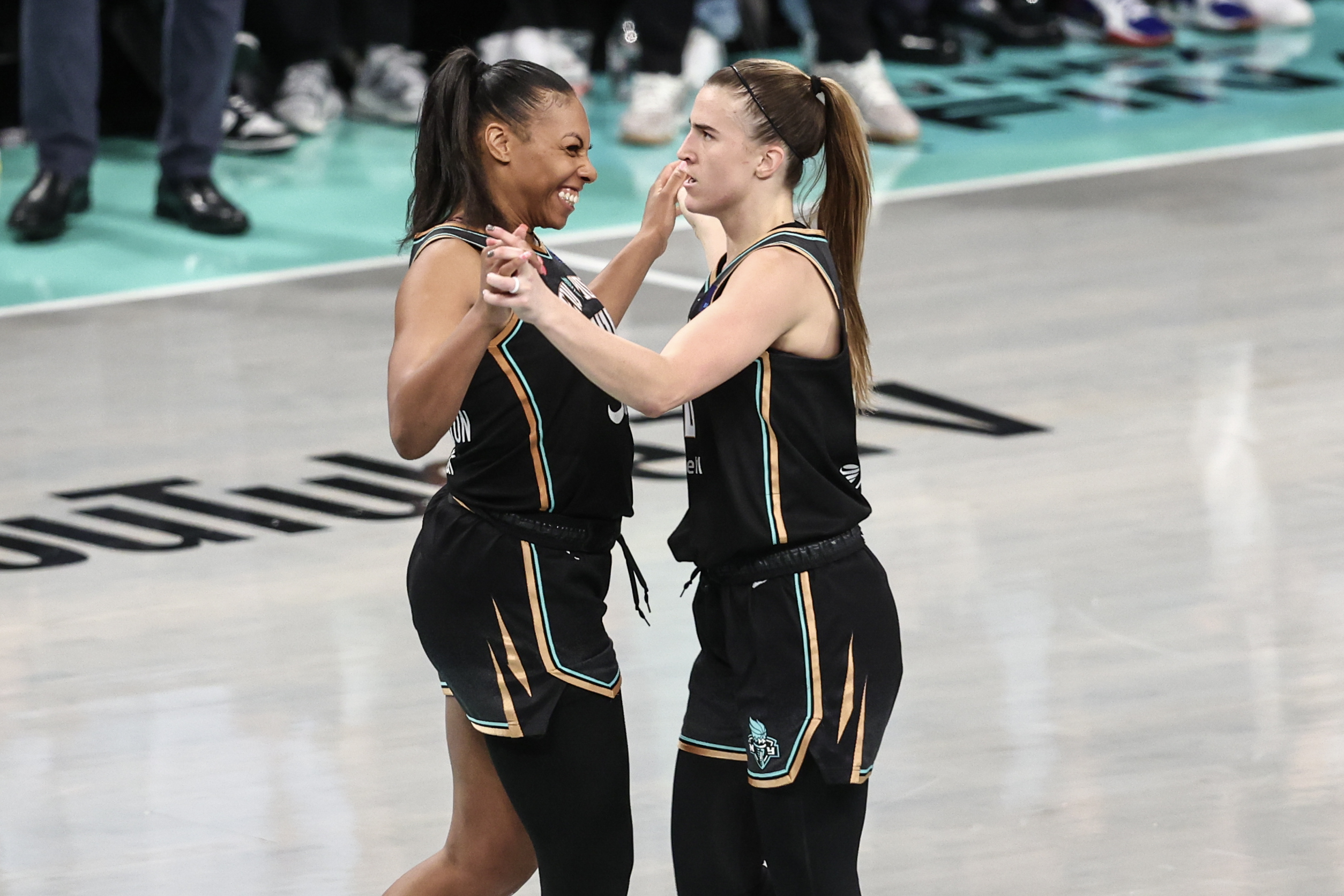 Betnijah Laney-Hamilton smiles wide while holding onto Sabrina Ionescu