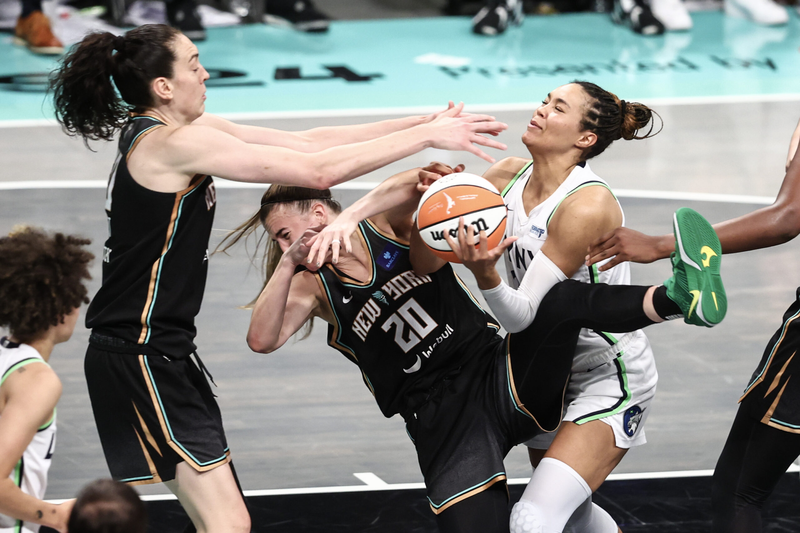 Napheesa Collier attempts to score the ball against Breanna Stewart and Sabrina Ionescu