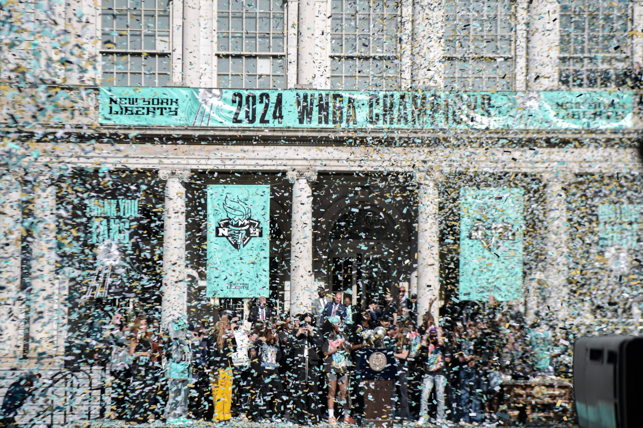 The New York Liberty are celebrated with confetti in front of city hall in New York City