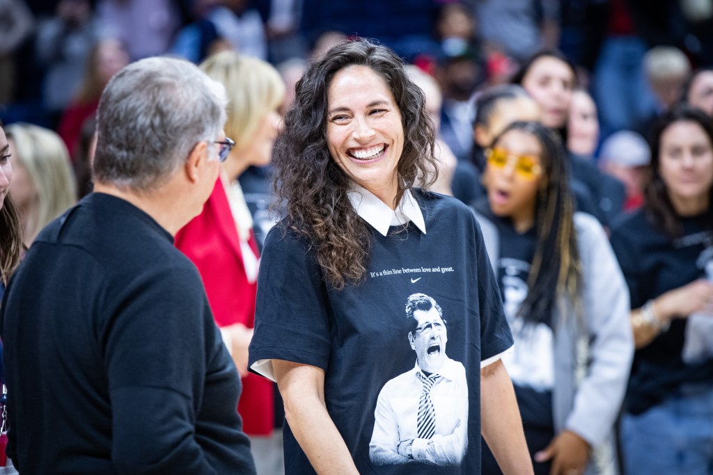 Sue Bird smiles at Geno Auriemma during the on-court celebration of Auriemma's record-breaking win.