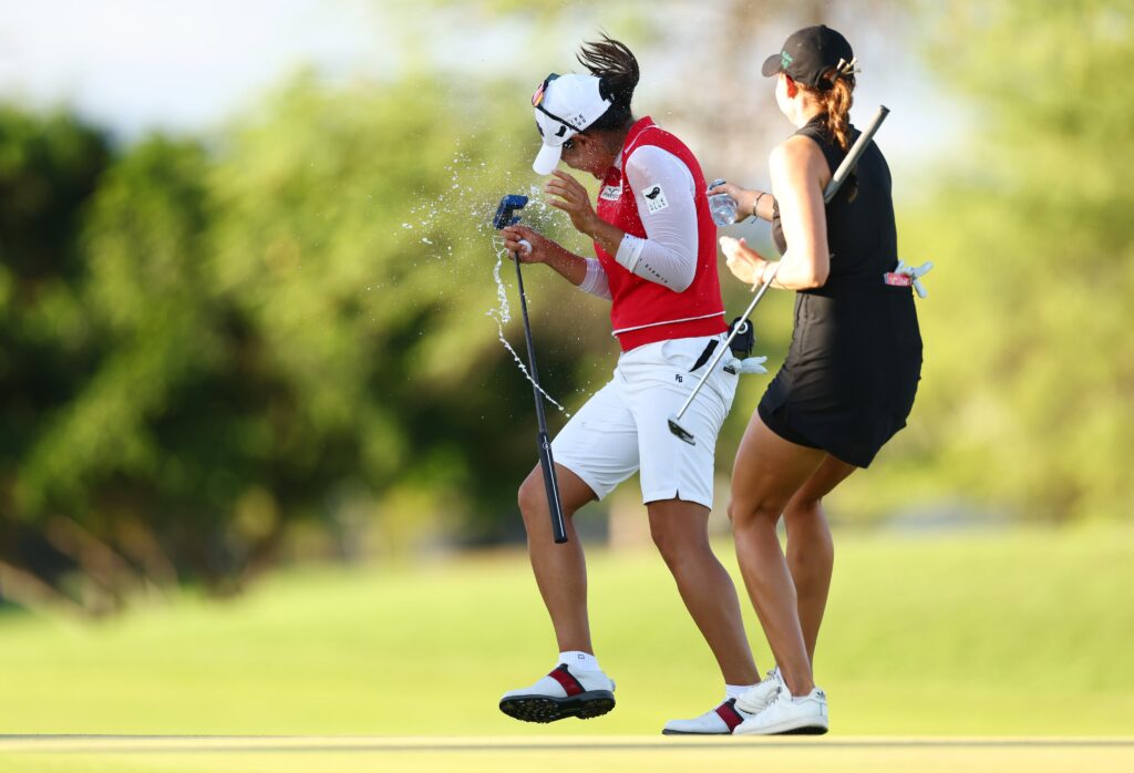 Nataliya Guseva sprays A Lim Kim with a water bottle following Kim's victory. Kim turns her head away from the spray and jumps back in excitement.