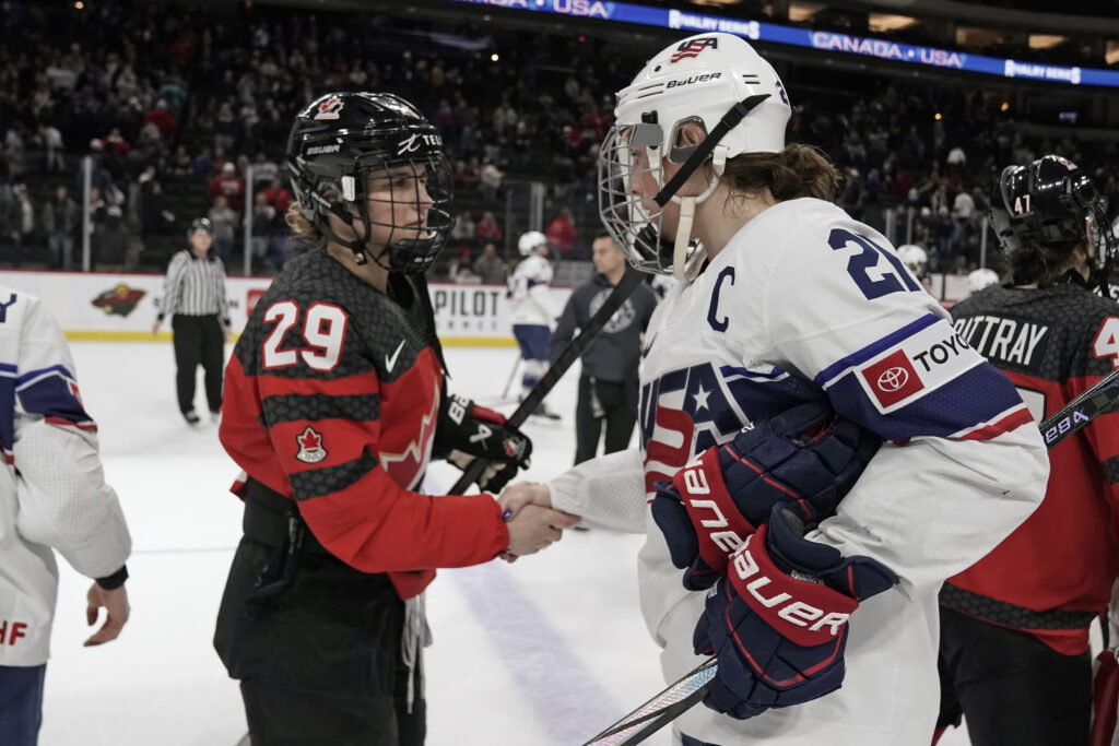 Team Canada forward Marie-Philip Poulin and Team USA forward Hilary Knight shake hands