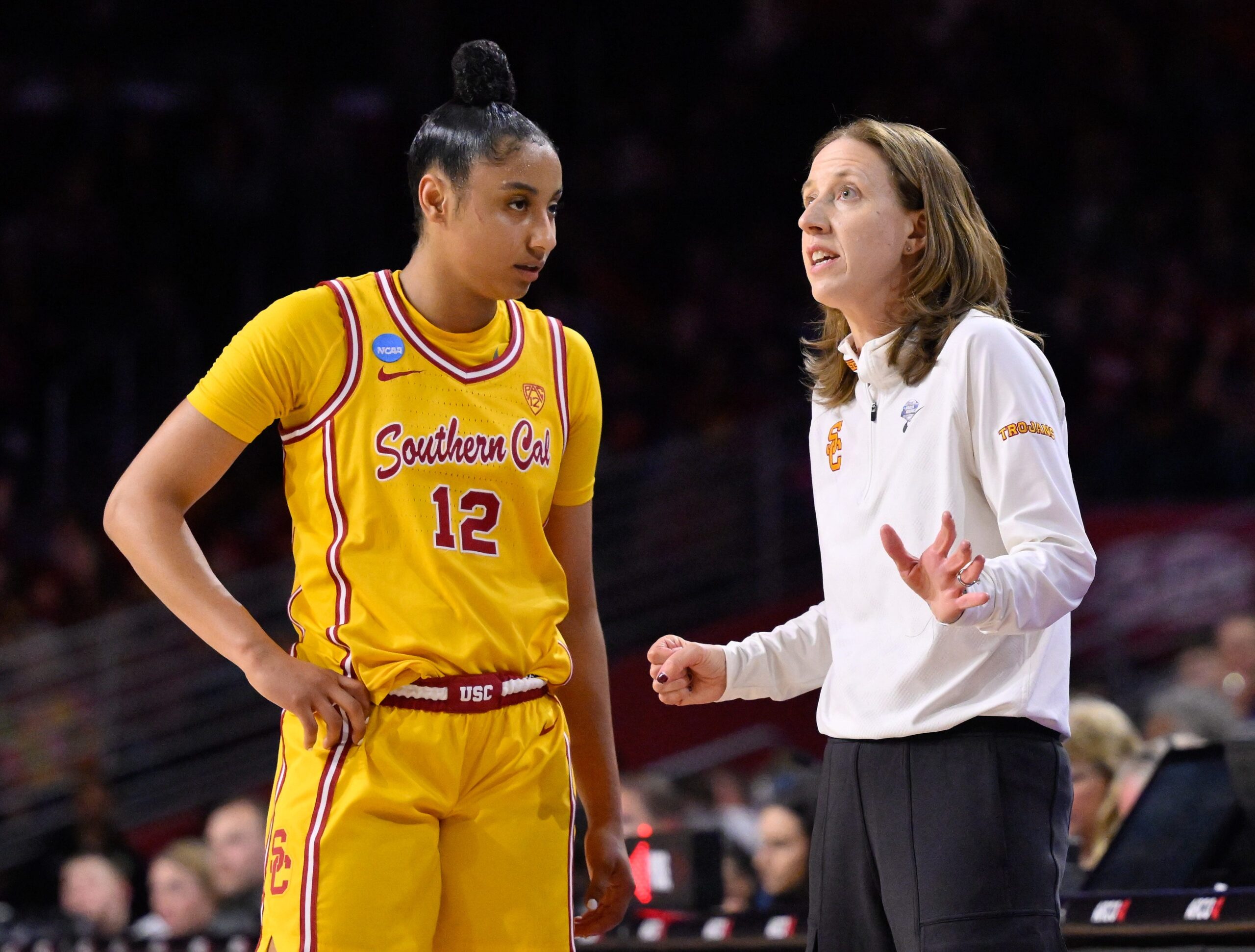USC guard JuJu Watkins looks at and listens to head coach Lindsay Gottlieb during a game.
