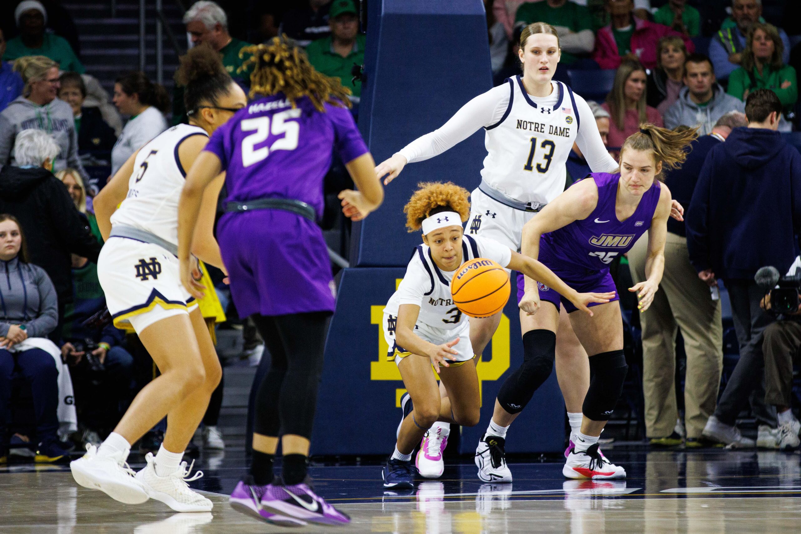Notre Dame guard Hannah Hidalgo reaches toward a loose ball in front of her with her right hand as she's playing defense.
