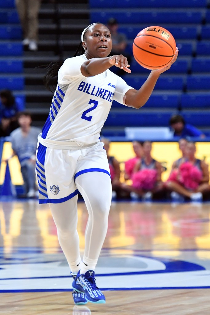 Shun'teria Anumele motions with her right hand and looks to pass the basketball she's holding level with her face in her left hand.