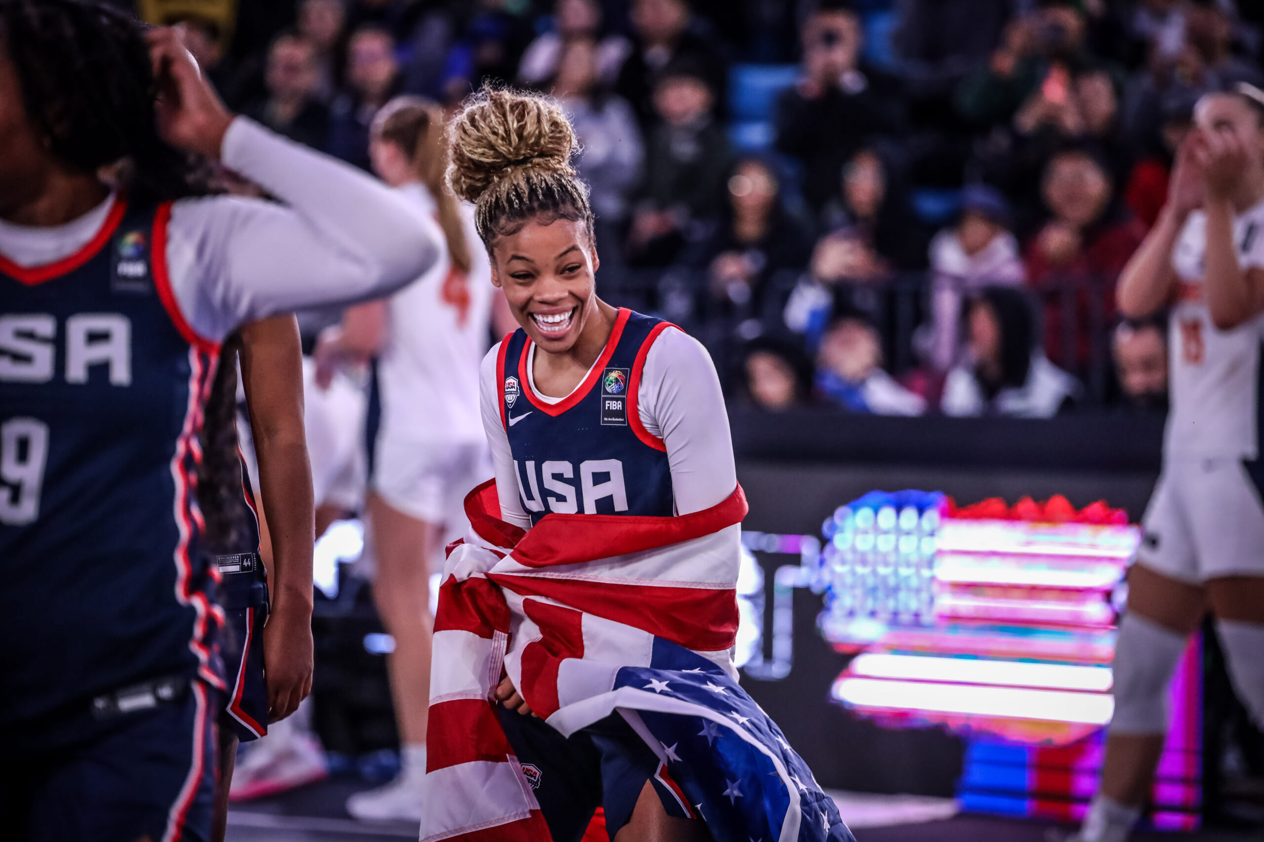 Team USA guard Harmoni Turner beams as she holds an American flag around herself after winning the gold-medal game of the 2024 FIBA 3x3 U23 World Cup.