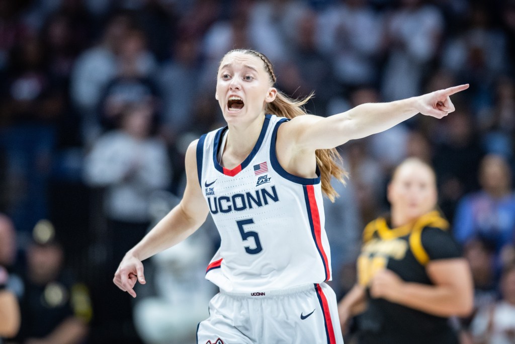 Paige Bueckers yells and points a direction to a teammate