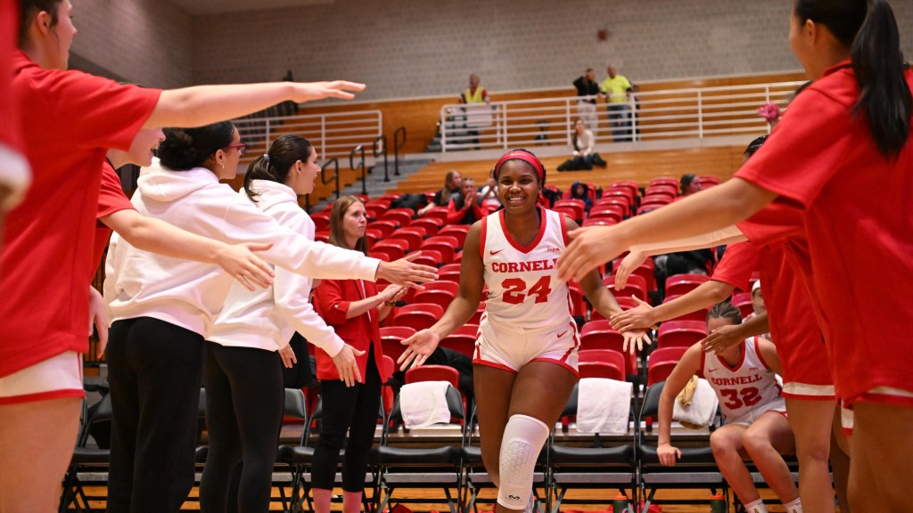 Cornell forward Summer Parker-Hall smiles and high-fives her teammates as she runs out on the court after hearing her name called in the starting lineup.