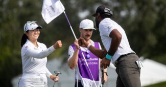 Rose Zhang extends a fist to celebrate with Sahith Theegala. A caddie holds the flag in the background.