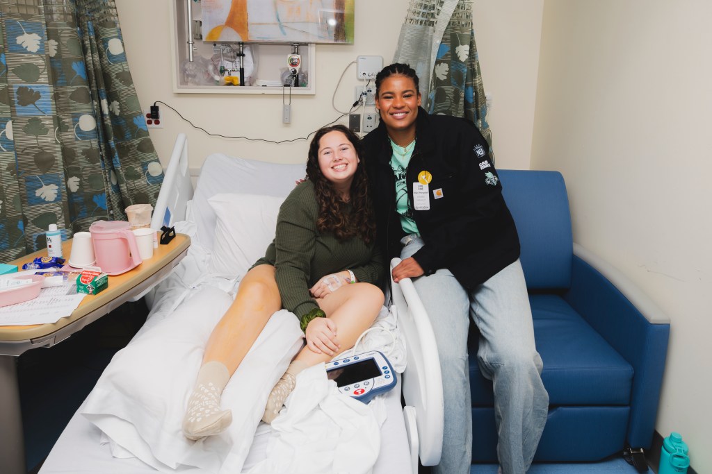 Nyara Sabally visits with a young person who plays college softball