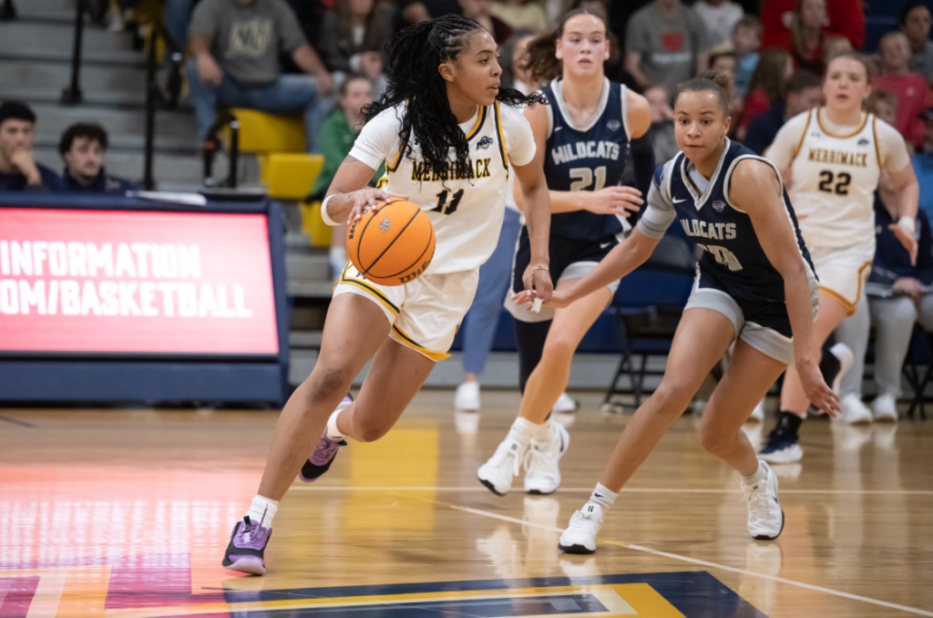 Thalia Sheppard dribbles the basketball in her right hand as she looks toward the Merrimack basket.