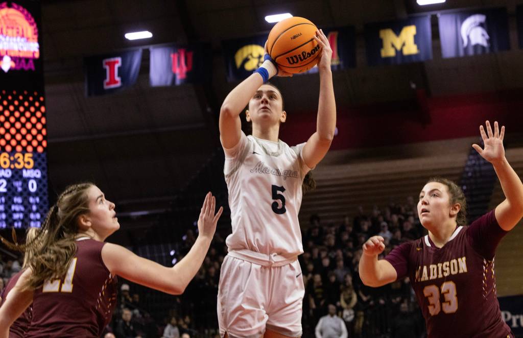 Manasquan forward Katie Collins shoots a jump shot. Two defenders are nearby, but neither is able to contest the shot.
