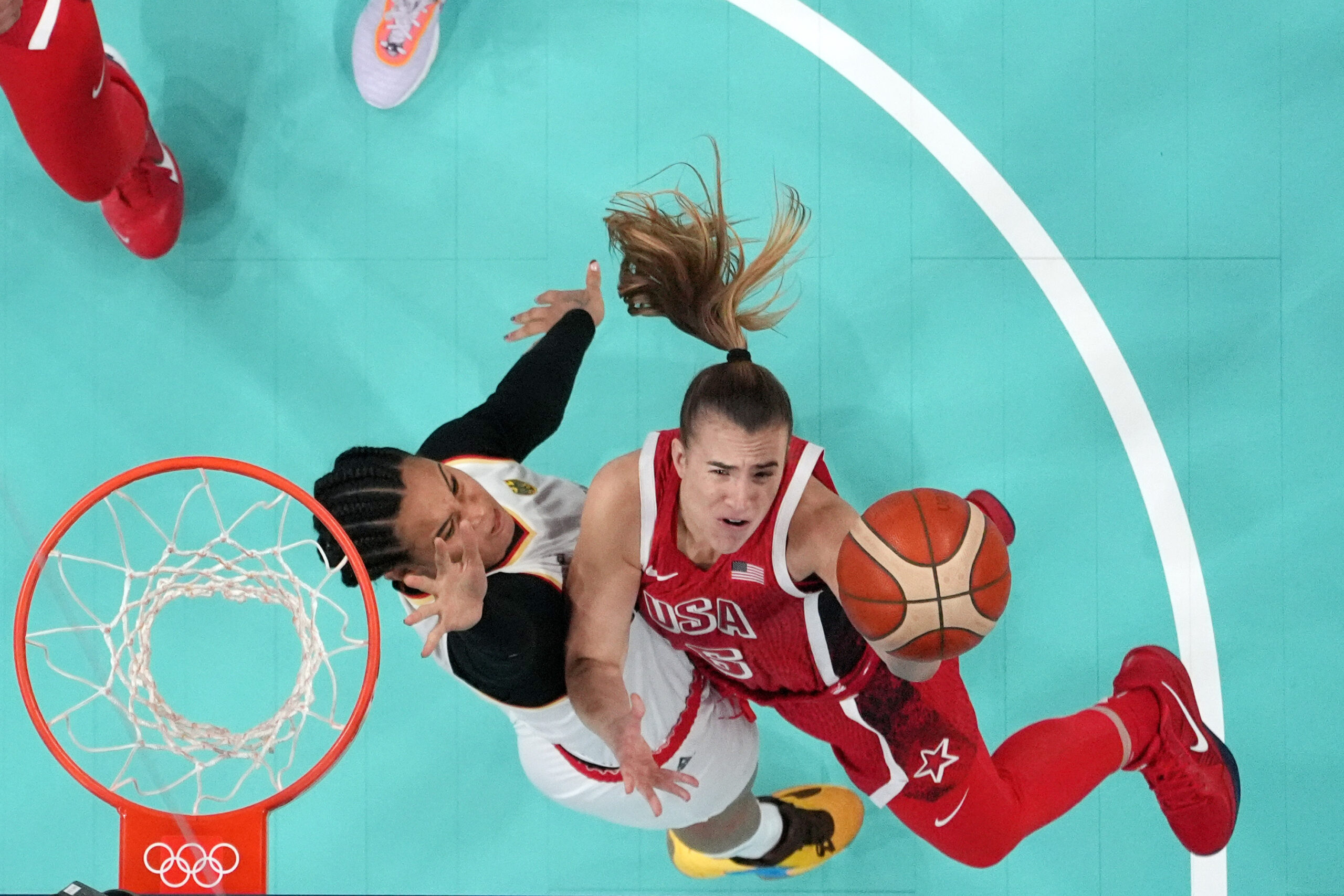 Sabrina Ionescu drives to the basket on former college teammate Satou Sabally