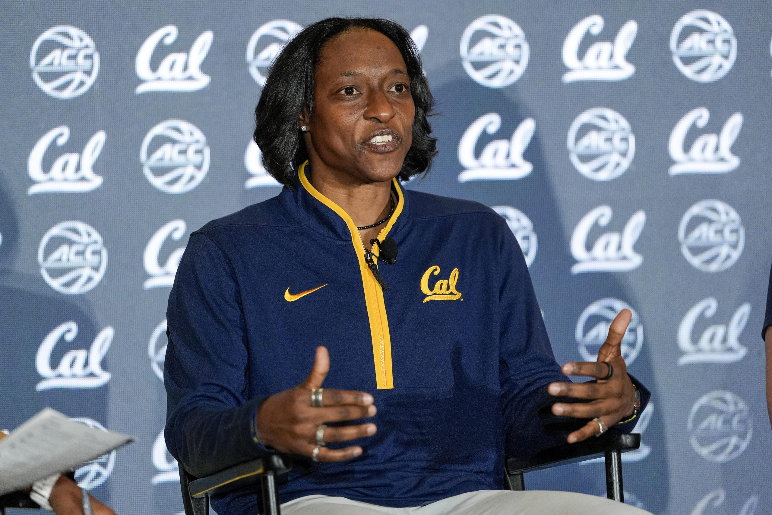 Cal head coach Charmin Smith gestures with both hands in front of her as she speaks at a podium during ACC media days.