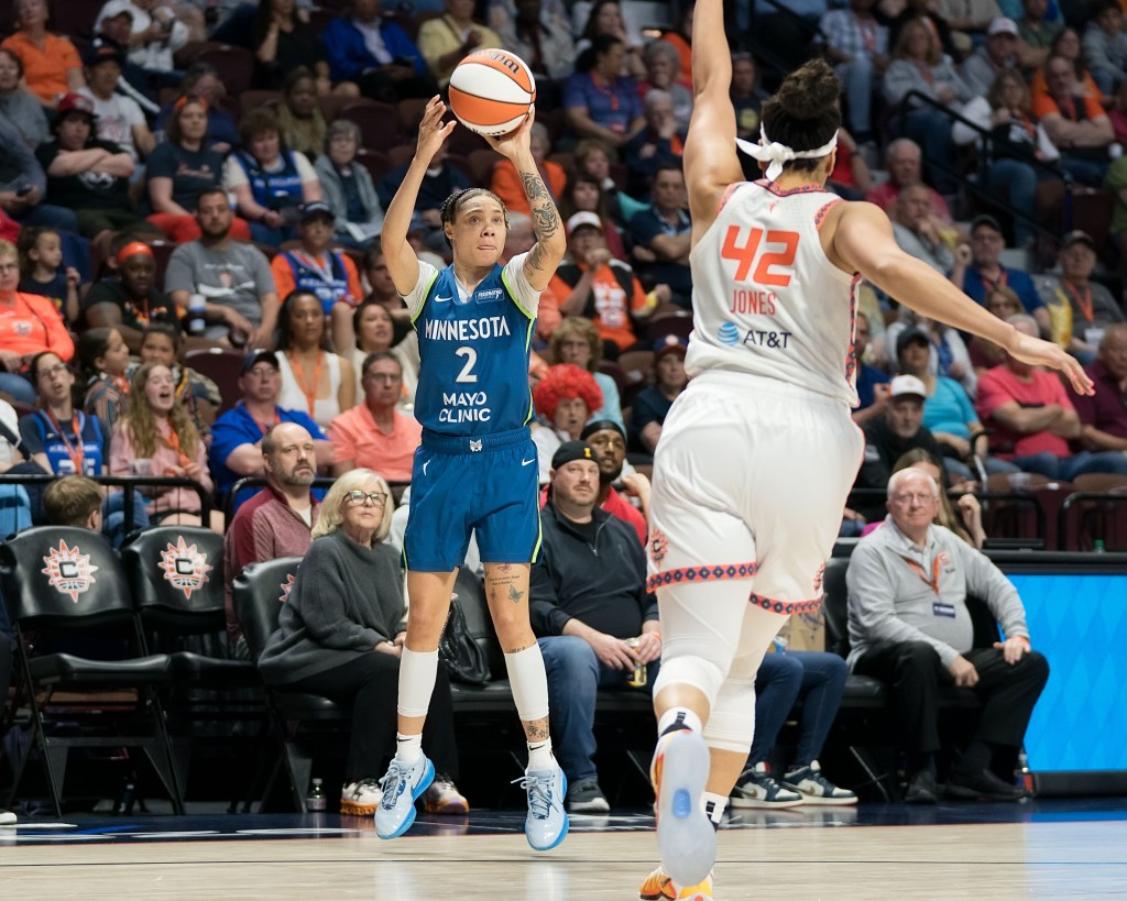 Natisha Hiedeman rises up for a long-range shot while Bri Jones runs at her with arm extended