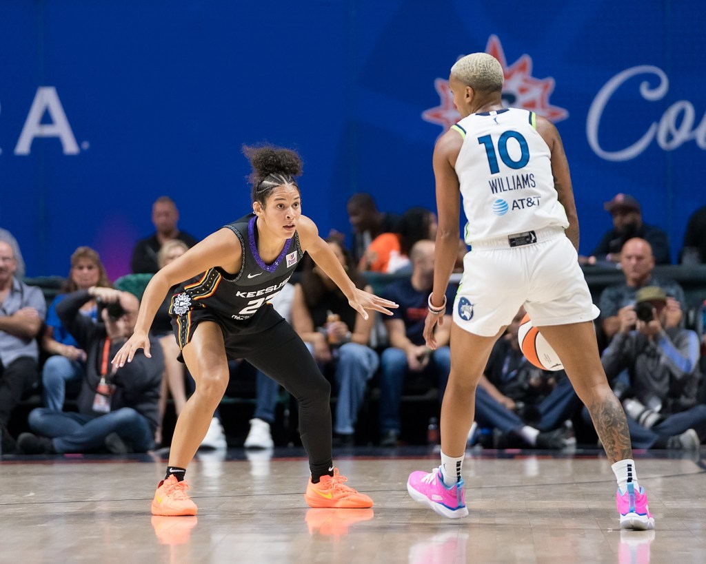 Veronica Burton gets into a stance against Courtney Williams who dribbles in front of her