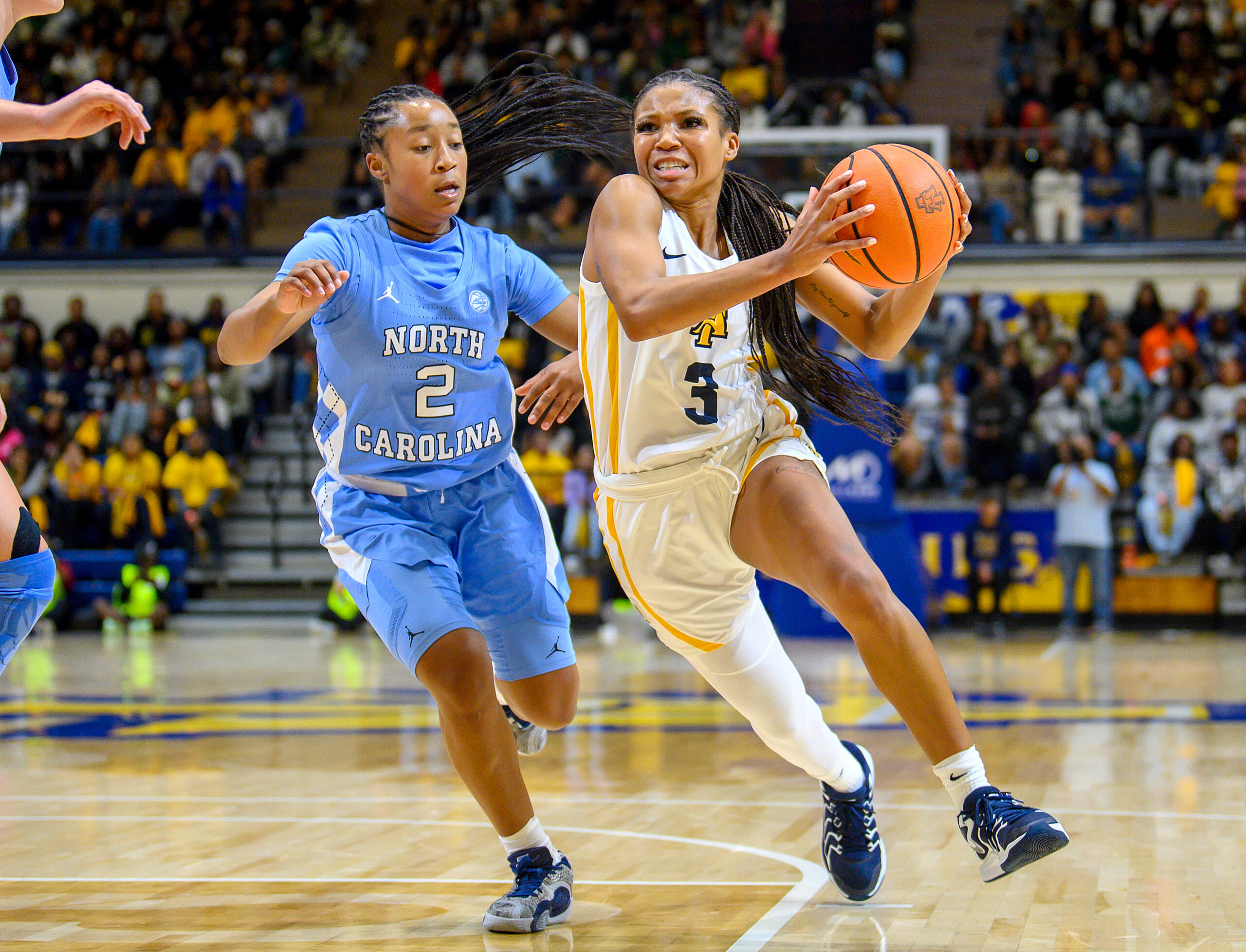 North Carolina A&T guard Reiven Douglas drives past UNC guard Grace Townsend in a game on Nov. 12. (Photo credit: Kevin Dorsey | North Carolina A&T)