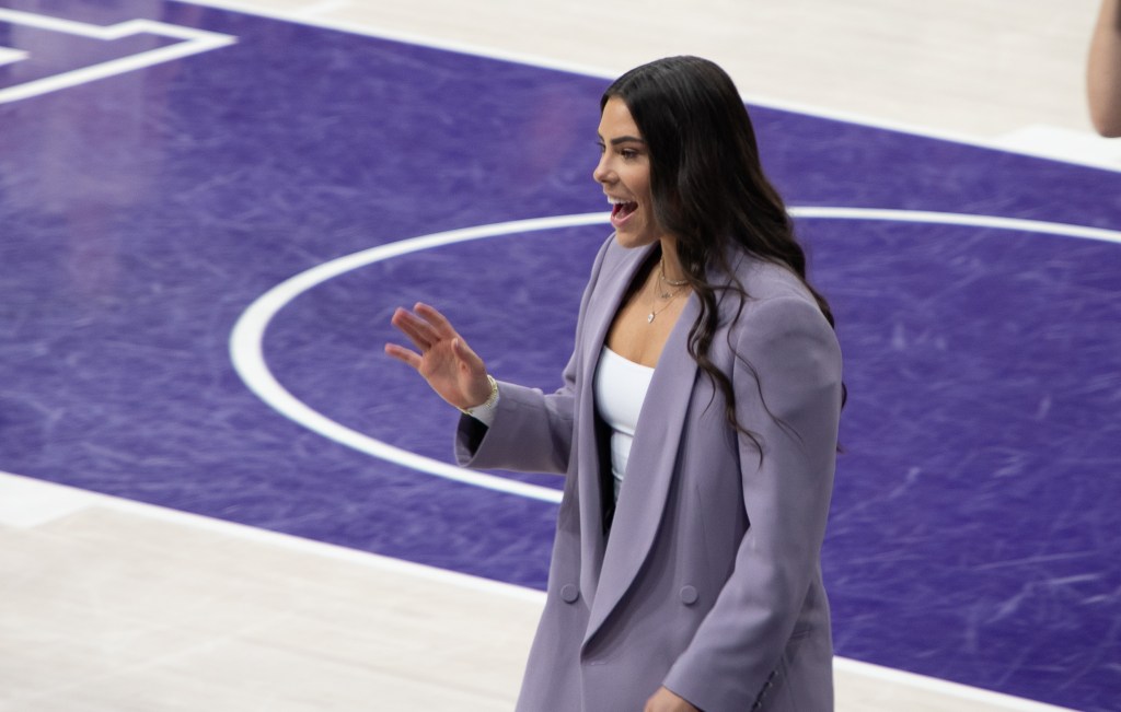 Kelsey Plum walks along the baseline and waves to fans ahead of her jersey retirement celebration.